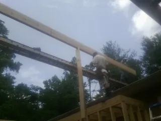 Carpenter setting a ridge beam over a new addition frame — Ice Dam Removal by Roofing Brothers in Landenberg