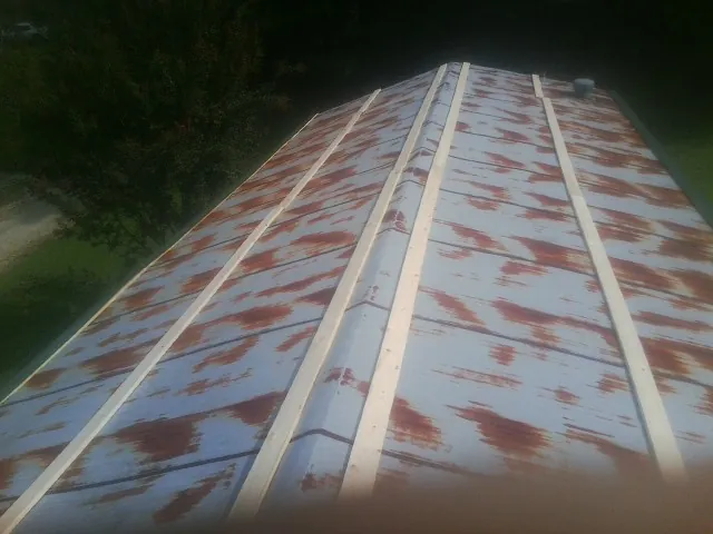 Rusted metal roof panels with new wood purlins before replacement — Storm Damage Roof Repair in Landenberg by Roofing Brothers