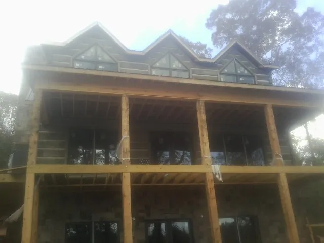 Dormers and porch framing on a large log home under construction — Roof Coating work by our crew in Landenberg