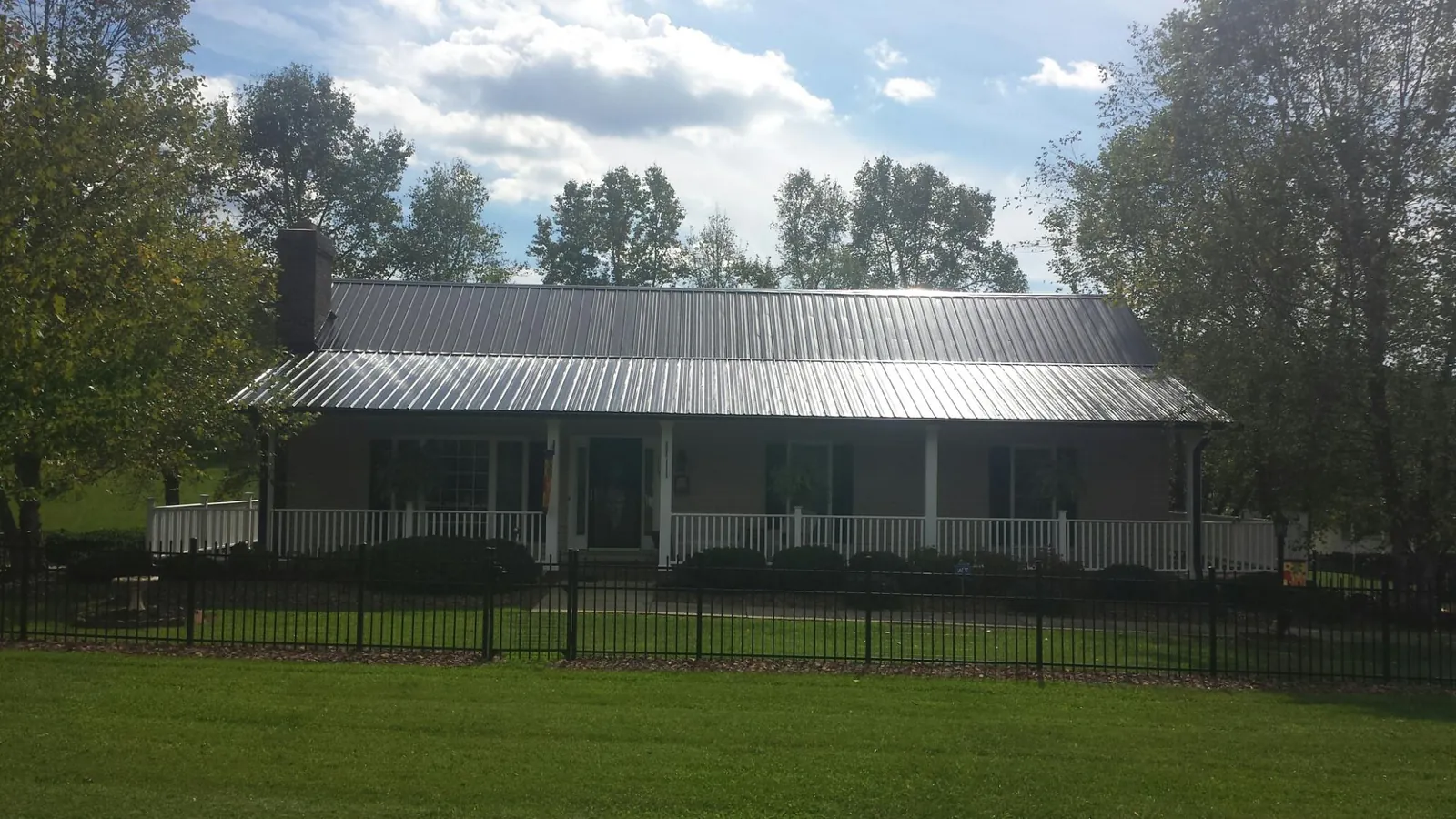 Gray metal roof on a brick ranch with a full width front porch — Gutter Guard Installation work by our crew in Landenberg