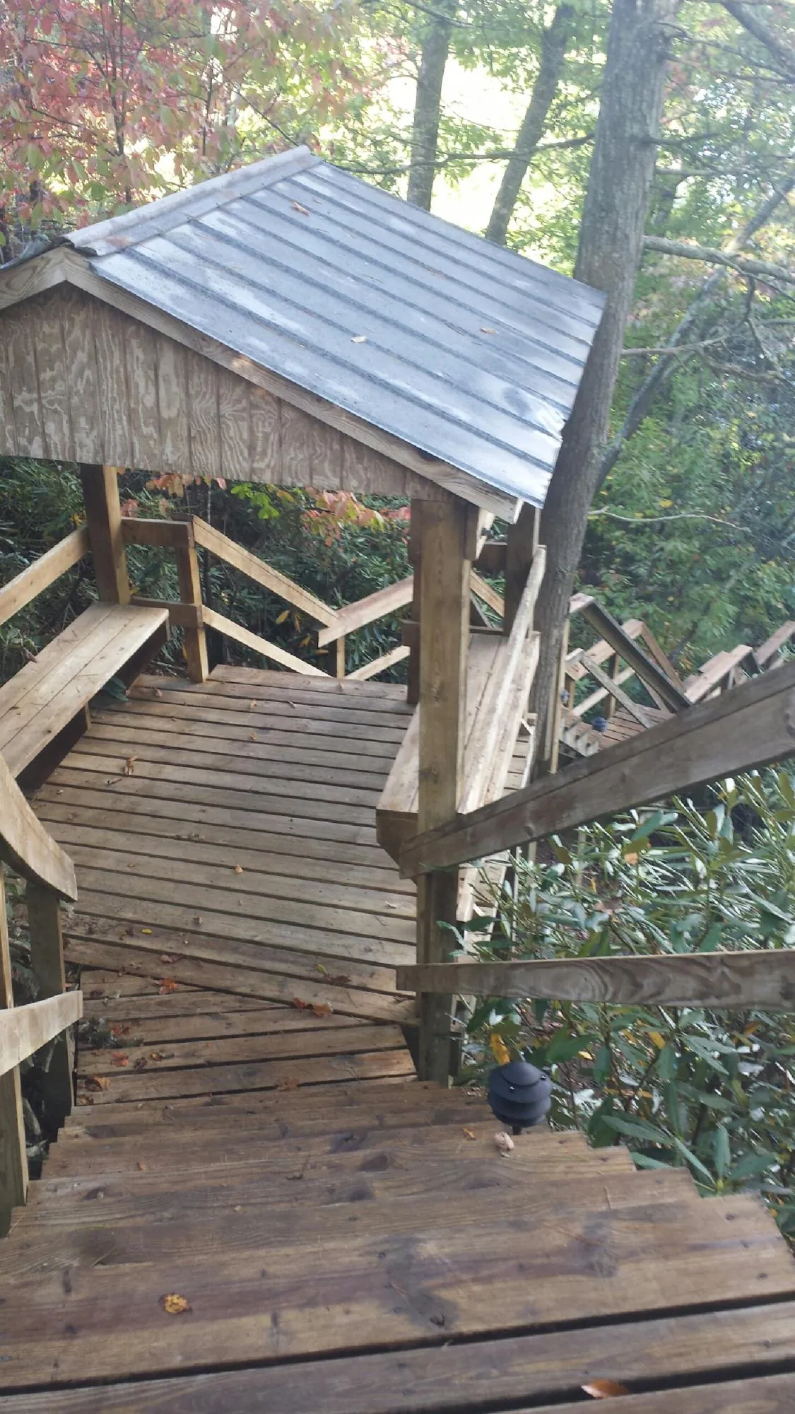 Metal roofed shelter over wooden steps on a wooded walkway — Skylight Repair & Installation work by our crew in Landenberg
